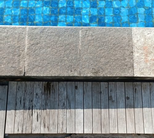 A,Pool,With,A,Gray,Stone,Border,And,A,Wooden